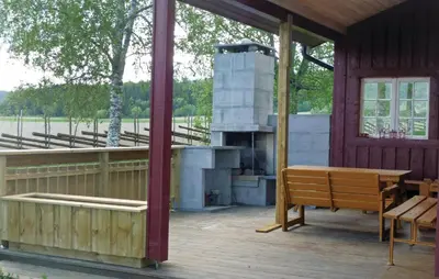 a porch with a grill and a wooden bench at Haug Isakplassen in Steinkjer