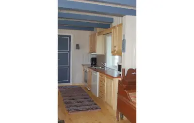 a kitchen with wooden cabinets and a sink at Haug Isakplassen in Steinkjer