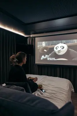 a woman sitting on a bed watching a movie at Sogndal Fjordpanorama - The view in Sogndal