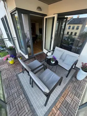 a patio with two chairs and a bench on a balcony at Modern Apartment - Amazing Terrace and Fjord View, Close to City Center in Bergen