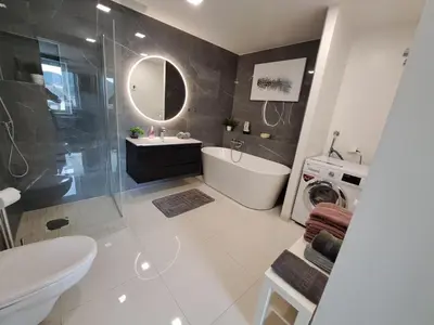 a bathroom with a tub and a sink and a toilet at Bergen sunrise Apartment - self check in - Free Parking in Bergen
