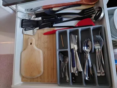 a drawer filled with utensils and a cutting board at Bergen sunrise Apartment - self check in - Free Parking in Bergen