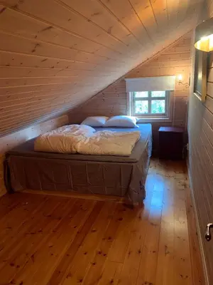 a bed in a wooden room in a attic at Hytto in Håra