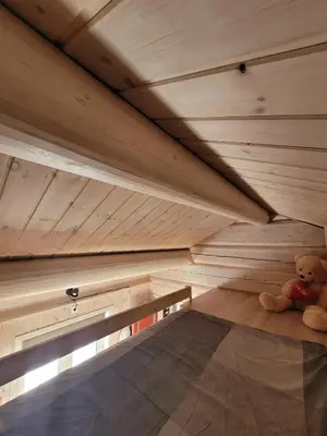 a teddy bear sitting on the floor of a sauna at ReveEnka - cabin in Trysil with Jacuzzi for rent in Trysil