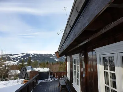 a porch of a house with a view of a mountain at ReveEnka - cabin in Trysil with Jacuzzi for rent in Trysil
