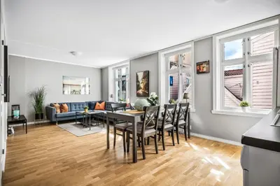 a living room with a table and chairs and a couch at Dragesmauet Apartments in Bergen