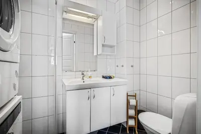 a white bathroom with a sink and a toilet at Dragesmauet Apartments in Bergen