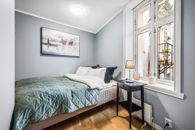 a bedroom with a bed and a window at Dragesmauet Apartments in Bergen