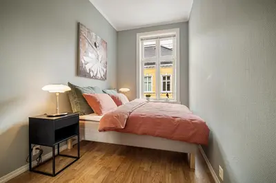 a small bedroom with a bed and a window at Rosen Apartment in Bergen