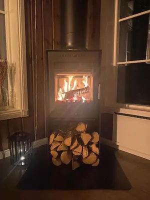 a pile of logs in front of a fireplace at Cabin with sauna in Trysil in Trysil