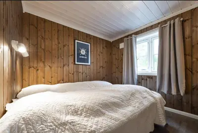 a bedroom with wood paneling and a bed and a window at Cabin with sauna in Trysil in Trysil