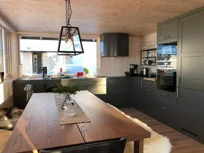 a kitchen with a wooden table and a large kitchen at New large cabin Ski in out Sjusjøen & sauna in Ringsaker