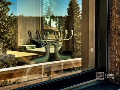 a window with two antlers in the reflection at New large cabin Ski in out Sjusjøen & sauna in Ringsaker