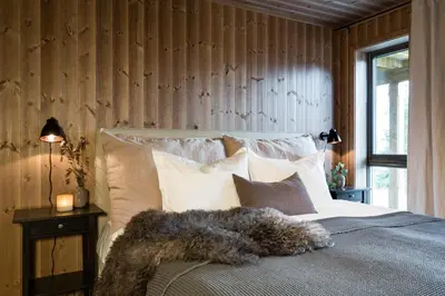 a bedroom with a bed with a pile of pillows at Cozy modern holiday villa with electric car charging, sauna and fireplace in Øyer