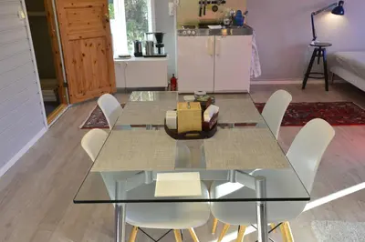 a dining room with a glass table and white chairs at Guesthouse in Manger, Radøy Island in Kollstad