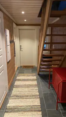 a hallway with a door and a rug on the floor at Penthouse by the ski lift, 4 bedrooms, 2 living rooms in Stranda