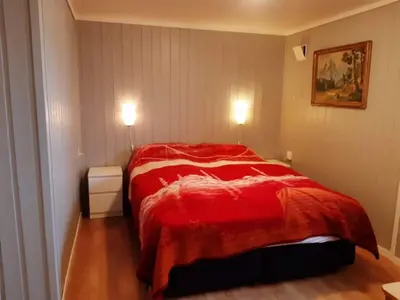 a bedroom with a red bed in a room at Fjord side apartment in Jondal