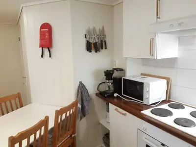 a kitchen with a microwave and a counter with a stove at Fjord side apartment in Jondal