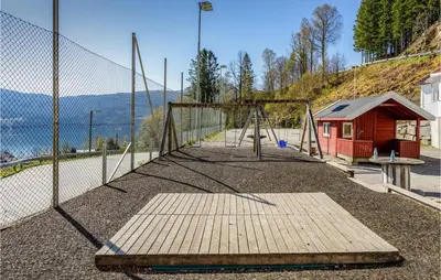 a swing set in a playground with a fence at Cozy Home In Vanvik With Wifi in Vanvik