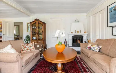 a living room with two couches and a table at Amazing Home In Skjoldastraumen in Skjoldastraumen
