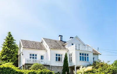 a white house with a balcony on top of it at Amazing Home In Skjoldastraumen in Skjoldastraumen