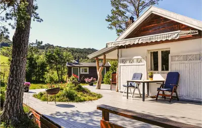 a house with a deck with a table and chairs at Lovely Home In Bjoa With Kitchen in Utbjoa