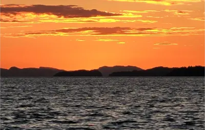 a sunset over the water with mountains in the background at Gorgeous Home In Reksteren With Kitchen in Hope
