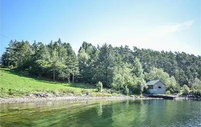 a small house on the shore of a river at Lovely Home In Fjelberg With Wifi in Sæbø