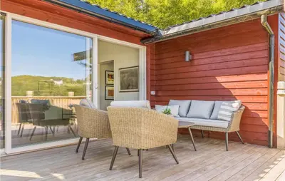 a patio with chairs and a couch on a deck at Cozy Home In Sveio With Wifi in Sveio
