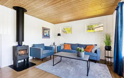 a living room with a blue couch and a stove at Cozy Home In Sveio With Wifi in Sveio