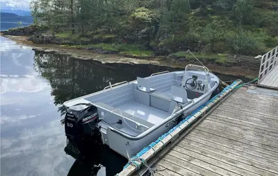 a small boat tied to a dock on the water at Sjøbris in Erve