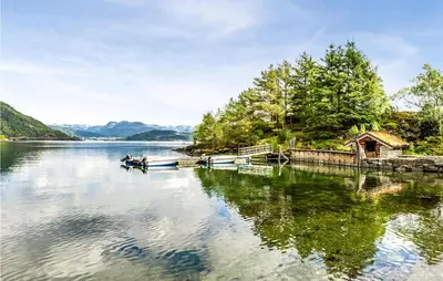 a couple of boats are docked on a lake at Sjøbris in Erve