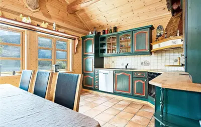a kitchen with green cabinets and a table and chairs at Awesome Home In Etne With Sauna in Erve