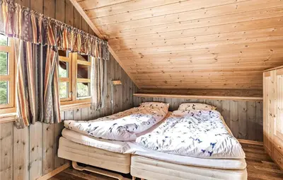 a bedroom with a bed in a wooden cabin at Awesome Home In Etne With Sauna in Erve