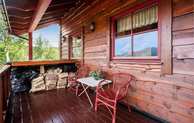 a porch with a table and chairs and a fireplace at Cozy Home In Norheimsund With Sauna in Norheimsund