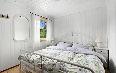 a white bedroom with a bed and a mirror at Cozy Home In Norheimsund With Sauna in Norheimsund