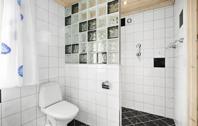 a bathroom with a toilet and a shower at Cozy Home In Norheimsund With Sauna in Norheimsund