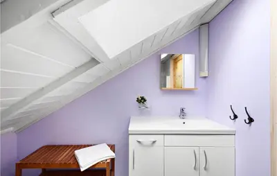a bathroom with purple walls and a sink and a mirror at Cozy Home In Norheimsund With Sauna in Norheimsund