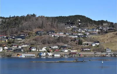 a small town on a hill next to a body of water at 3 Bedroom Amazing Home In Norheimsund in Norheimsund