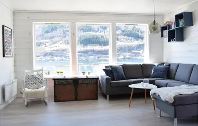 a living room with a couch and a large window at 3 Bedroom Amazing Home In Norheimsund in Norheimsund