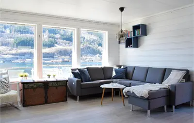 a living room with a couch and a large window at 3 Bedroom Amazing Home In Norheimsund in Norheimsund