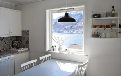 a kitchen with a table and a large window at 3 Bedroom Amazing Home In Norheimsund in Norheimsund