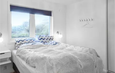 a white bedroom with a large bed with a window at Gorgeous Home In Stolmen With Kitchen