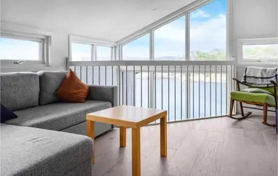 a living room with a couch and a table at Gorgeous Home In Stolmen With Kitchen