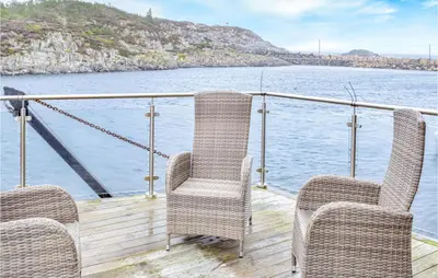 three chairs on a deck of a boat on the water at Gorgeous Home In Stolmen With Kitchen