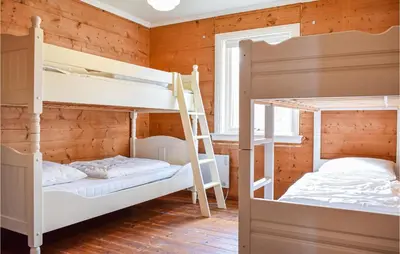 two bunk beds in a room with wooden walls at Amazing Home In Torangsvåg With Wifi in Skår