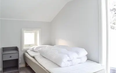 a white room with a bed with a window at Lovely Home In Masfjordnes With Wifi in Masfjorden