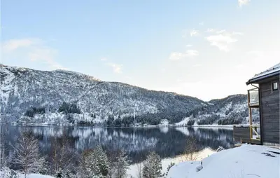 a cabin with a view of a lake in the snow at Lovely Home In Masfjordnes With Wifi in Masfjorden