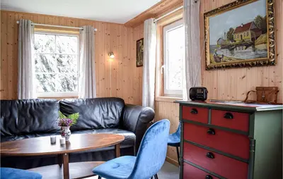 a living room with a leather couch and a table at 2 Bedroom Cozy Home In Stolmen