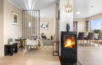 a living room with a fireplace and a dining room at 2 Bedroom Nice Home In Fana in Fanahammaren